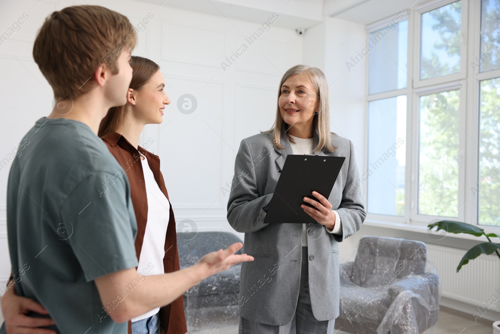 Smiling real estate agent working with couple at home Photo of Smiling real estate agent working with couple at home