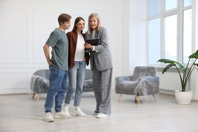 Photo of Real estate agent working with couple at home