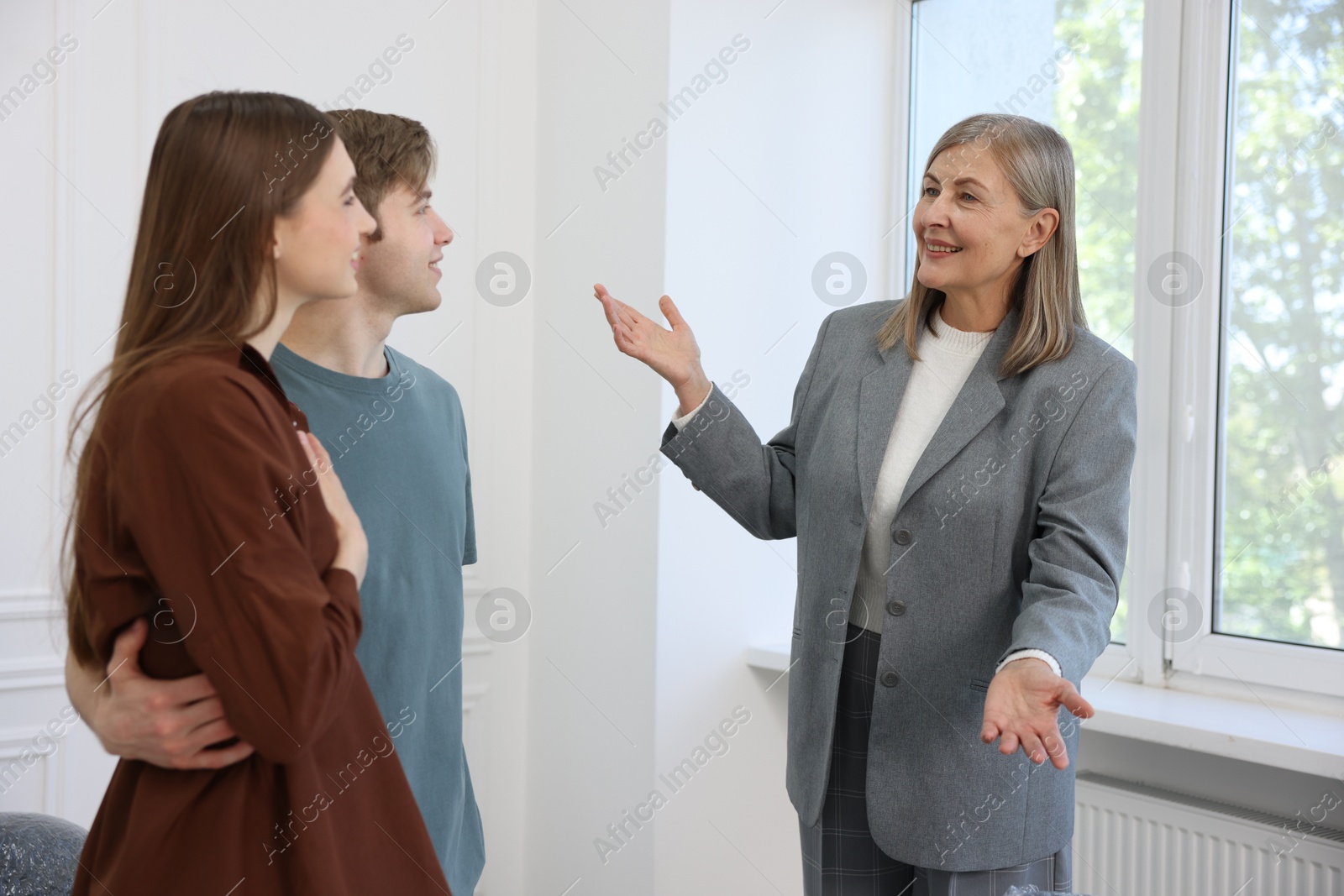 Smiling real estate agent working with couple at home Photo of Smiling real estate agent working with couple at home