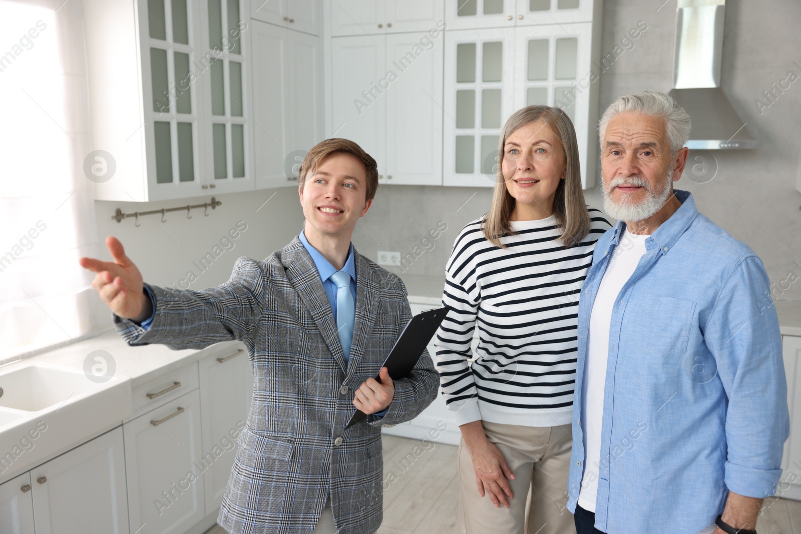 Smiling real estate agent showing apartment to couple indoors Photo of Smiling real estate agent showing apartment to couple indoors