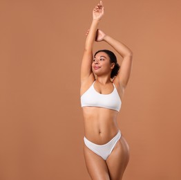 Photo of Woman in white underwear with smooth skin after epilation procedure on beige background, space for text