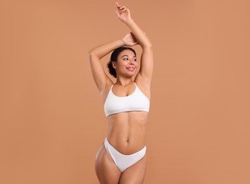 Photo of Woman in white underwear with smooth skin after epilation procedure on beige background