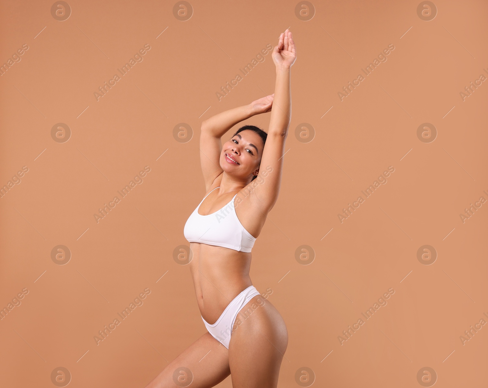 Woman in white underwear with smooth skin after epilation procedure on beige background Photo of Woman in white underwear with smooth skin after epilation procedure on beige background