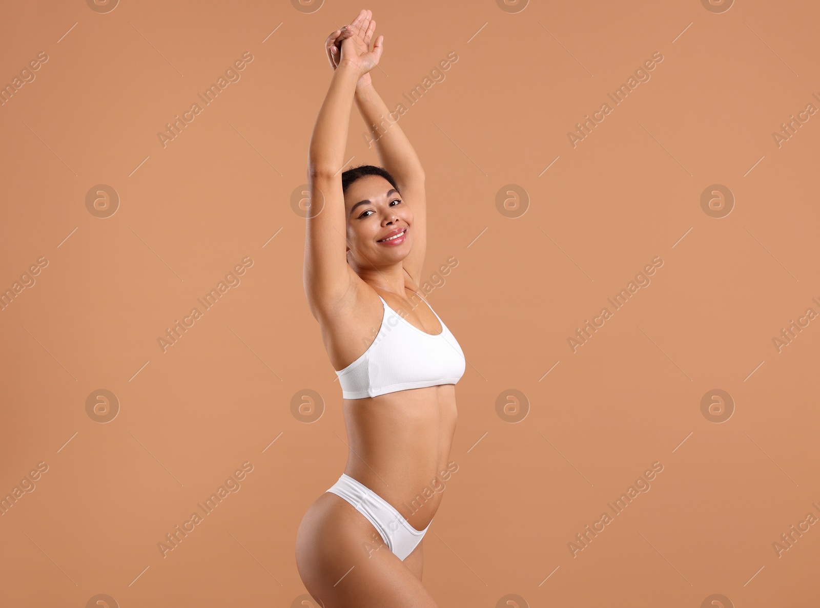 Woman in white underwear with smooth skin after epilation procedure on beige background Photo of Woman in white underwear with smooth skin after epilation procedure on beige background