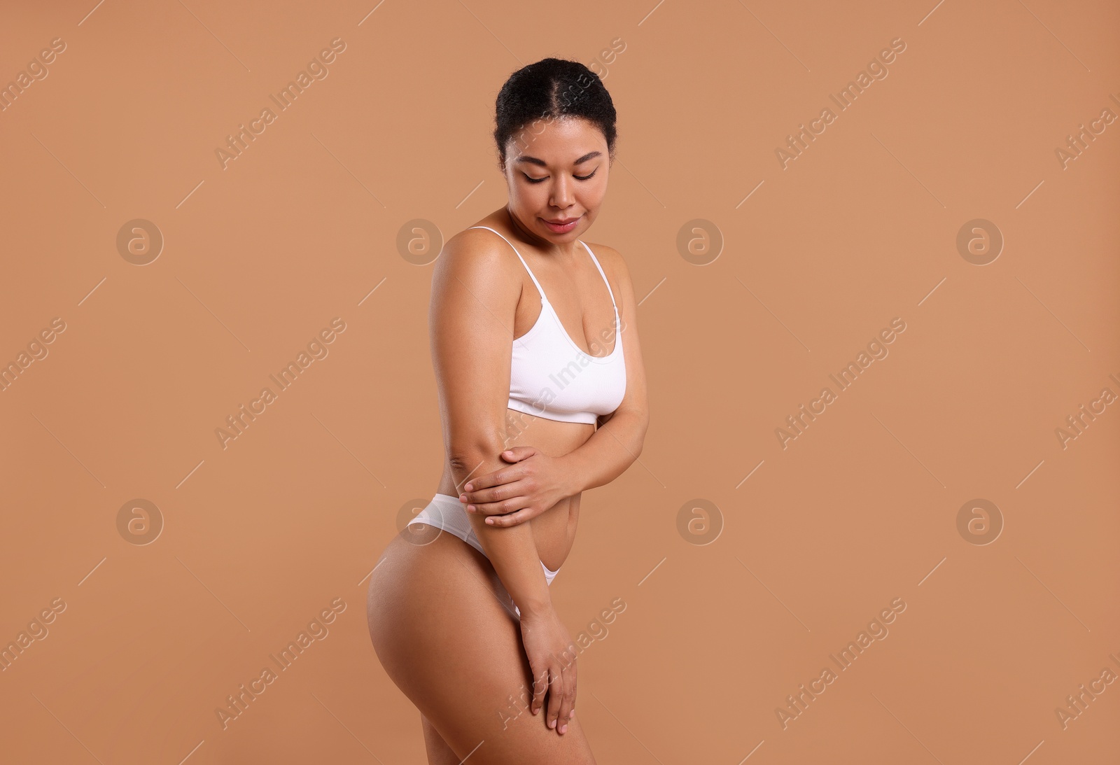 Woman in white underwear with smooth skin after epilation procedure on beige background Photo of Woman in white underwear with smooth skin after epilation procedure on beige background