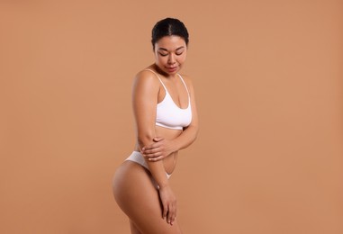 Photo of Woman in white underwear with smooth skin after epilation procedure on beige background
