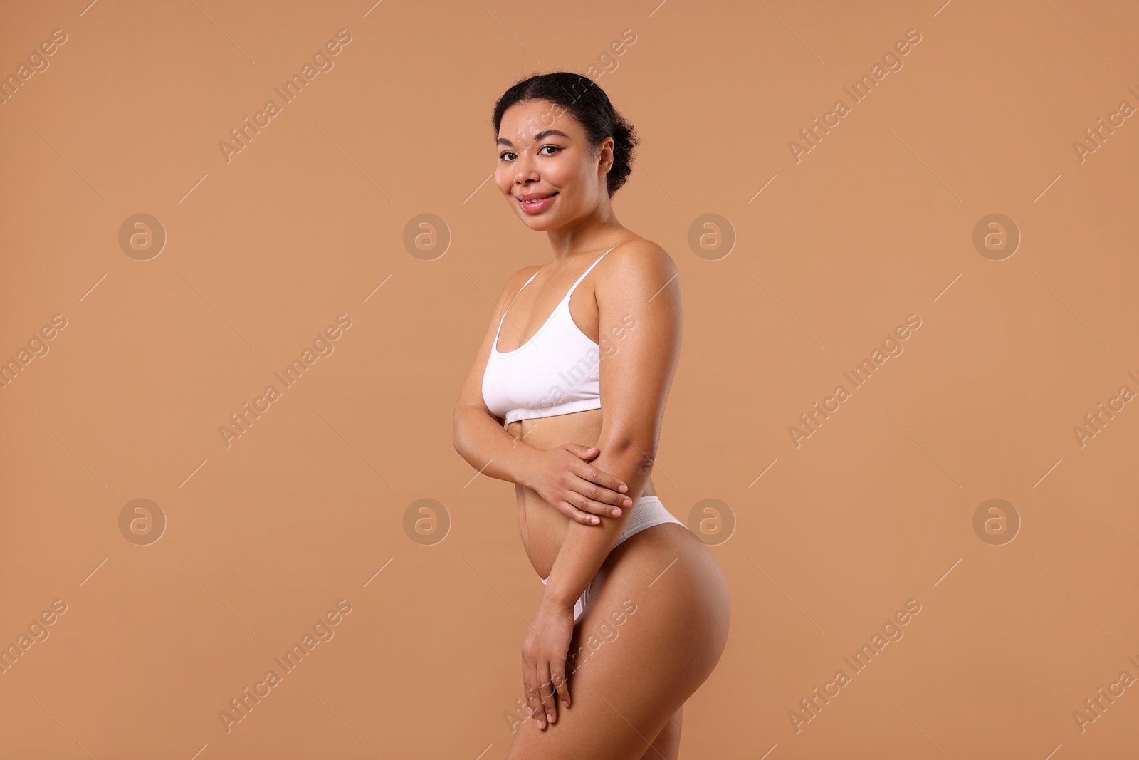 Woman in white underwear with smooth skin after epilation procedure on beige background Photo of Woman in white underwear with smooth skin after epilation procedure on beige background
