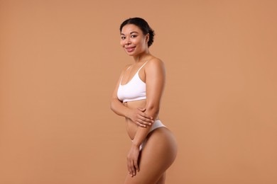 Photo of Woman in white underwear with smooth skin after epilation procedure on beige background