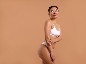 Photo of Woman in white underwear with smooth skin after epilation procedure on beige background, space for text