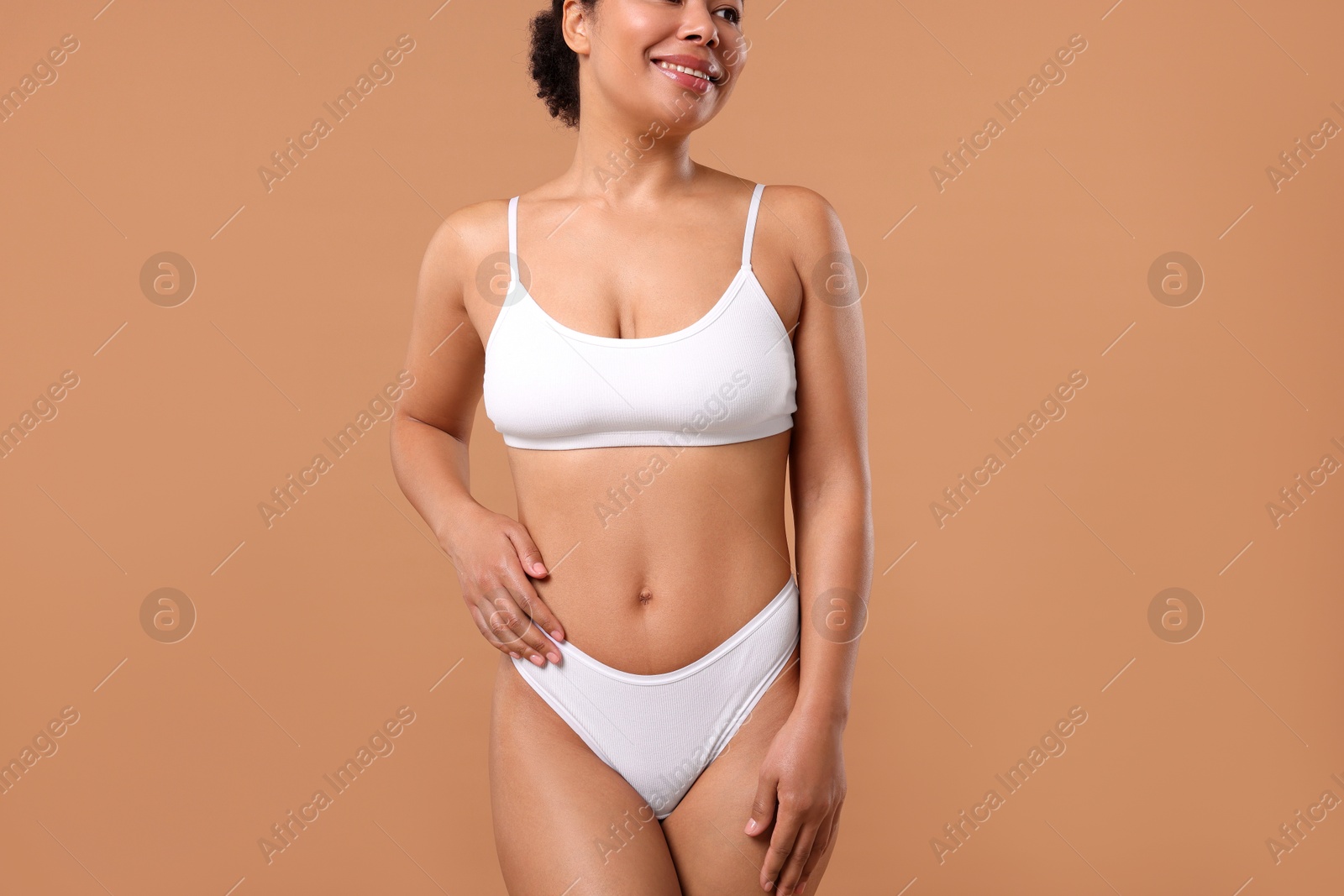 Woman in white underwear with smooth skin after epilation procedure on beige background, closeup Photo of Woman in white underwear with smooth skin after epilation procedure on beige background, closeup