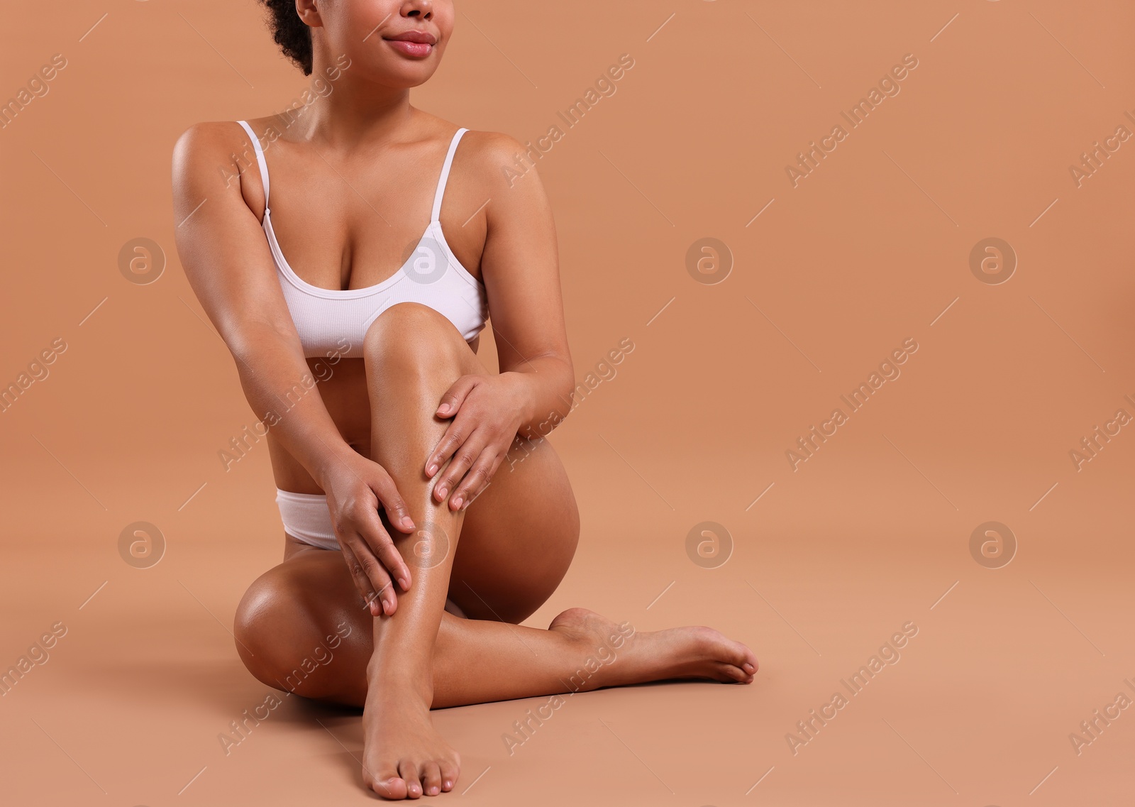 Woman in white underwear with smooth skin after epilation procedure on beige background, closeup. Space for text Photo of Woman in white underwear with smooth skin after epilation procedure on beige background, closeup. Space for text