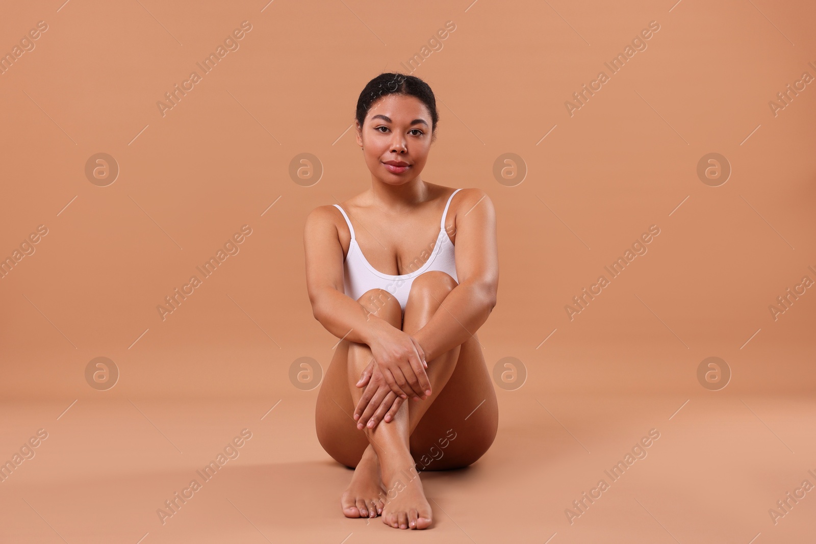 Woman in white underwear with smooth skin after epilation procedure on beige background Photo of Woman in white underwear with smooth skin after epilation procedure on beige background