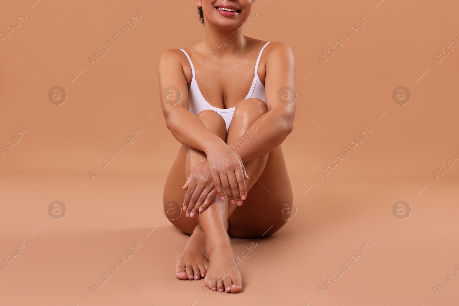 Woman in white underwear with smooth skin after epilation procedure on beige background, closeup Photo of Woman in white underwear with smooth skin after epilation procedure on beige background, closeup