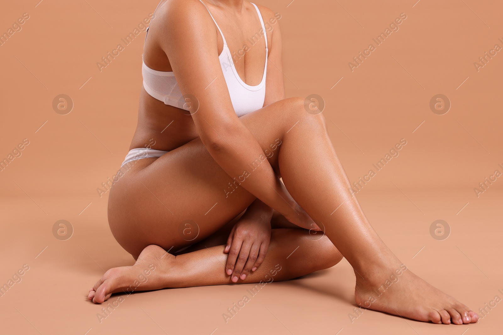 Woman in white underwear with smooth skin after epilation procedure on beige background, closeup Photo of Woman in white underwear with smooth skin after epilation procedure on beige background, closeup