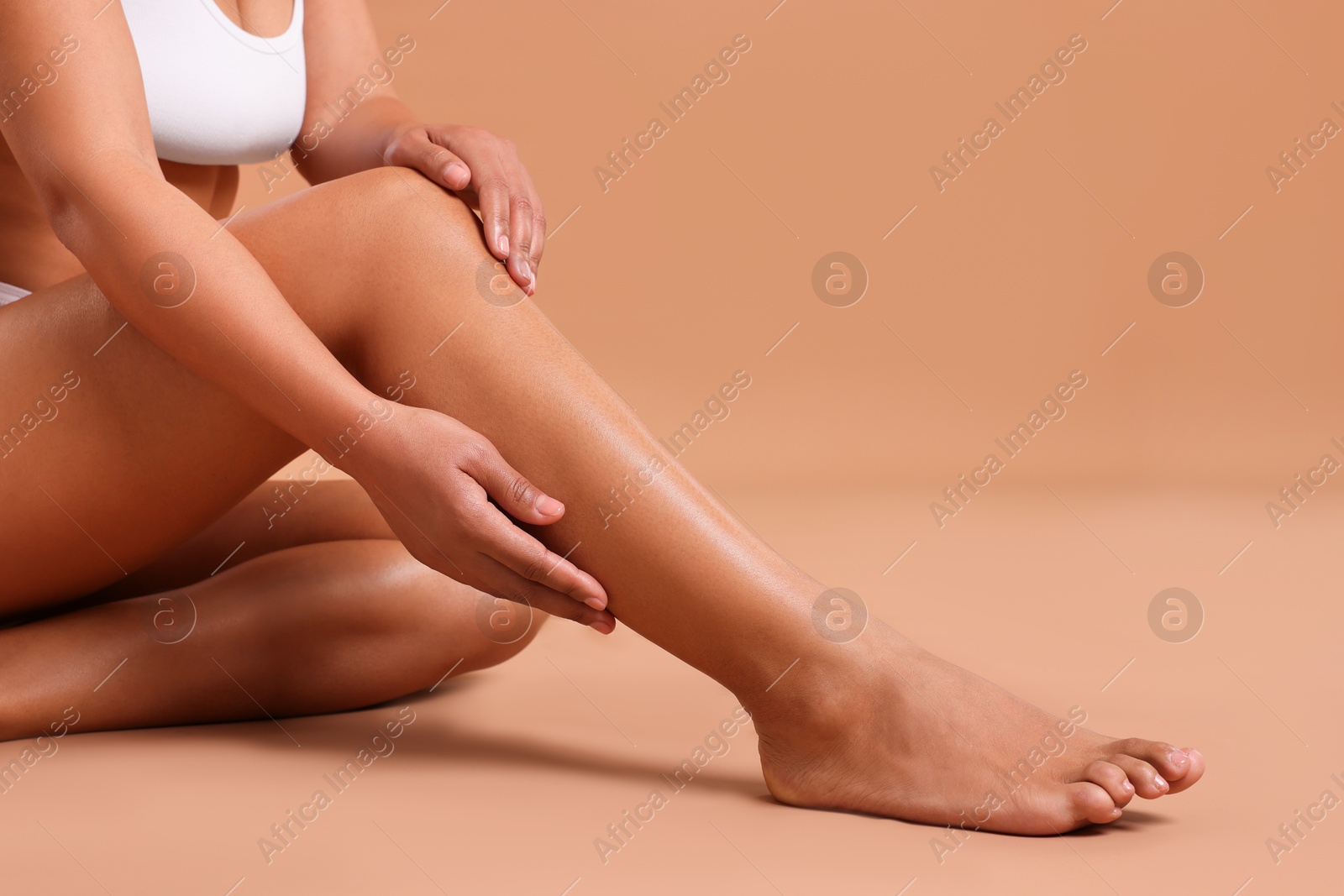 Epilation. Woman showing her legs with smooth soft skin on beige background, closeup Photo of Epilation. Woman showing her legs with smooth soft skin on beige background, closeup