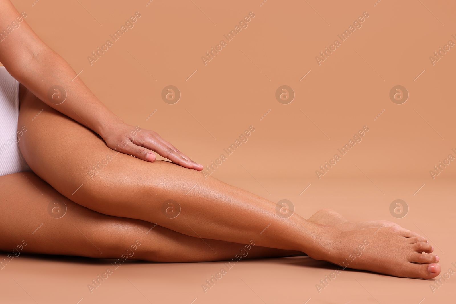 Epilation. Woman showing her legs with smooth soft skin on beige background, closeup Photo of Epilation. Woman showing her legs with smooth soft skin on beige background, closeup