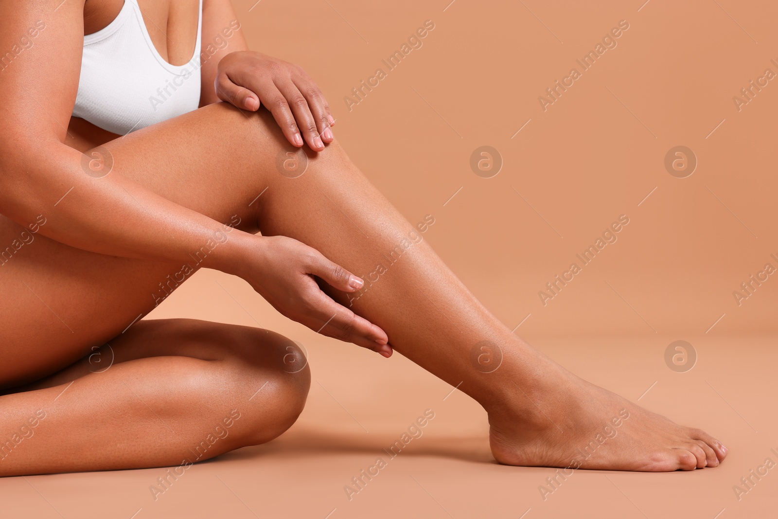 Epilation. Woman showing her legs with smooth soft skin on beige background, closeup Photo of Epilation. Woman showing her legs with smooth soft skin on beige background, closeup