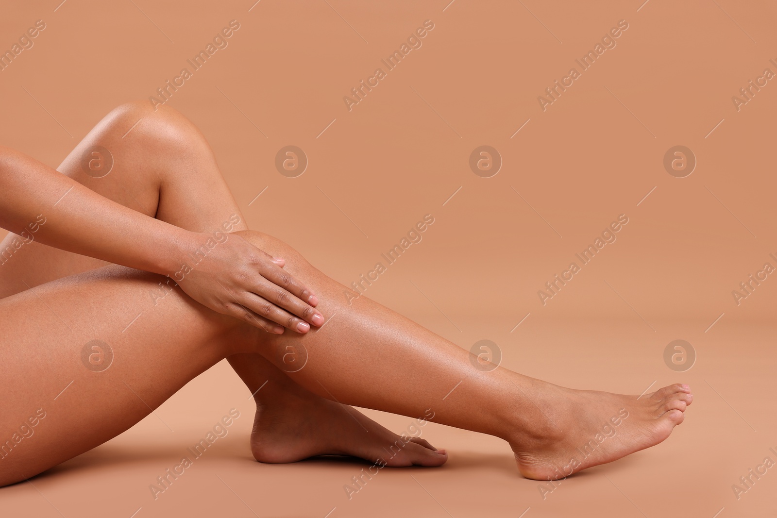Epilation. Woman showing her legs with smooth soft skin on beige background, closeup Photo of Epilation. Woman showing her legs with smooth soft skin on beige background, closeup