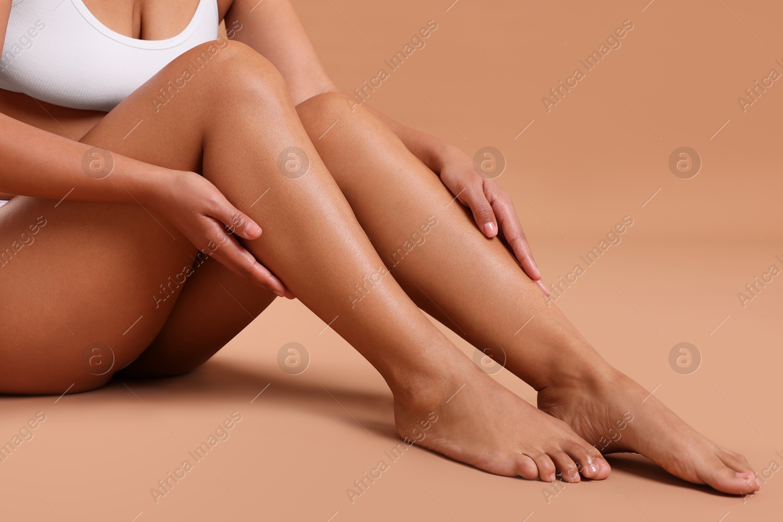 Epilation. Woman showing her legs with smooth soft skin on beige background, closeup Photo of Epilation. Woman showing her legs with smooth soft skin on beige background, closeup