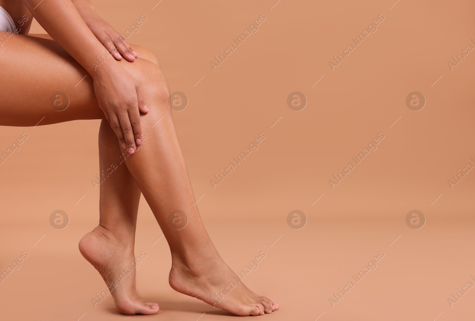 Epilation. Woman showing her legs with smooth soft skin on beige background, closeup. Space for text Photo of Epilation. Woman showing her legs with smooth soft skin on beige background, closeup. Space for text
