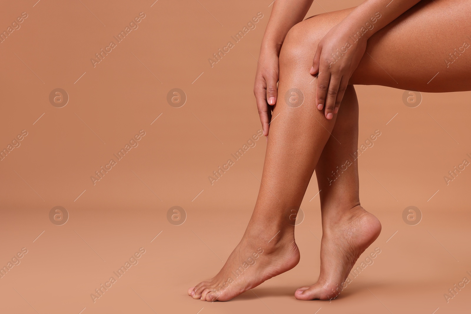 Epilation. Woman showing her legs with smooth soft skin on beige background, closeup. Space for text Photo of Epilation. Woman showing her legs with smooth soft skin on beige background, closeup. Space for text