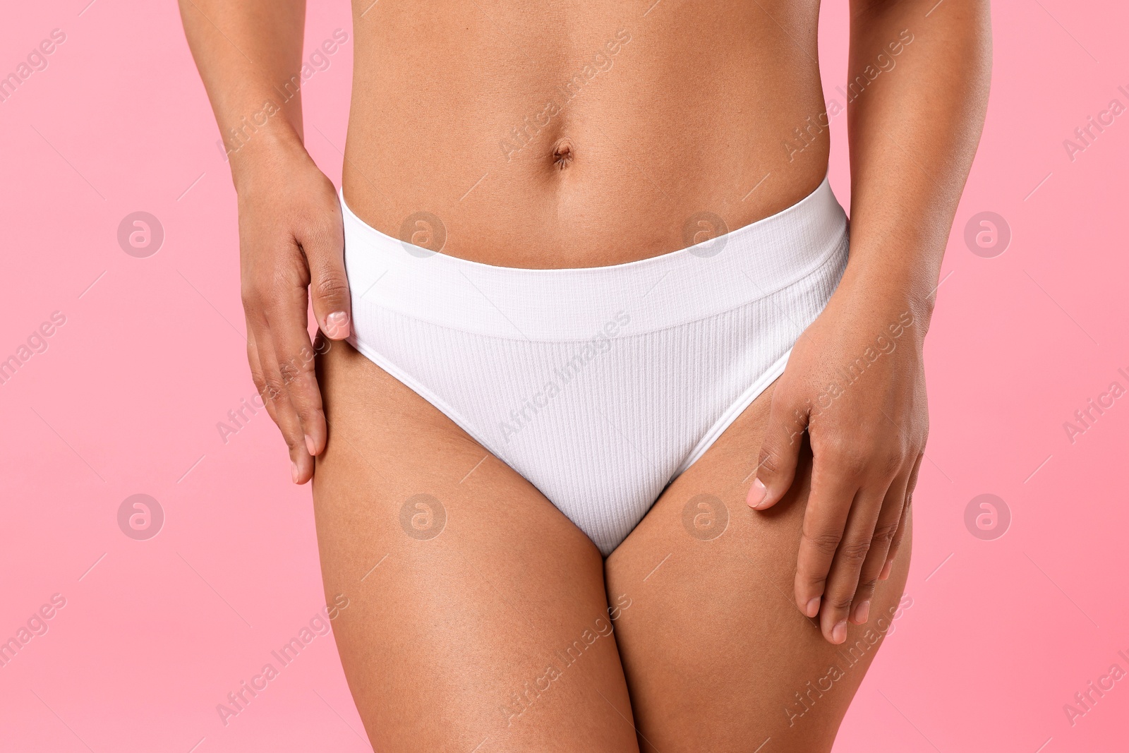 Woman in white underwear with smooth skin after epilation procedure on pink background, closeup Photo of Woman in white underwear with smooth skin after epilation procedure on pink background, closeup