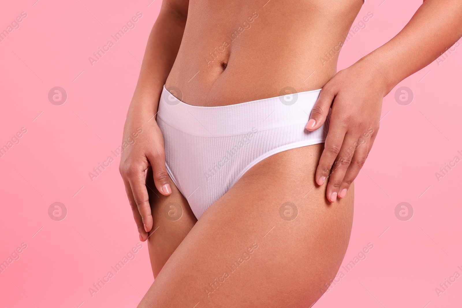 Woman in white underwear with smooth skin after epilation procedure on pink background, closeup Photo of Woman in white underwear with smooth skin after epilation procedure on pink background, closeup
