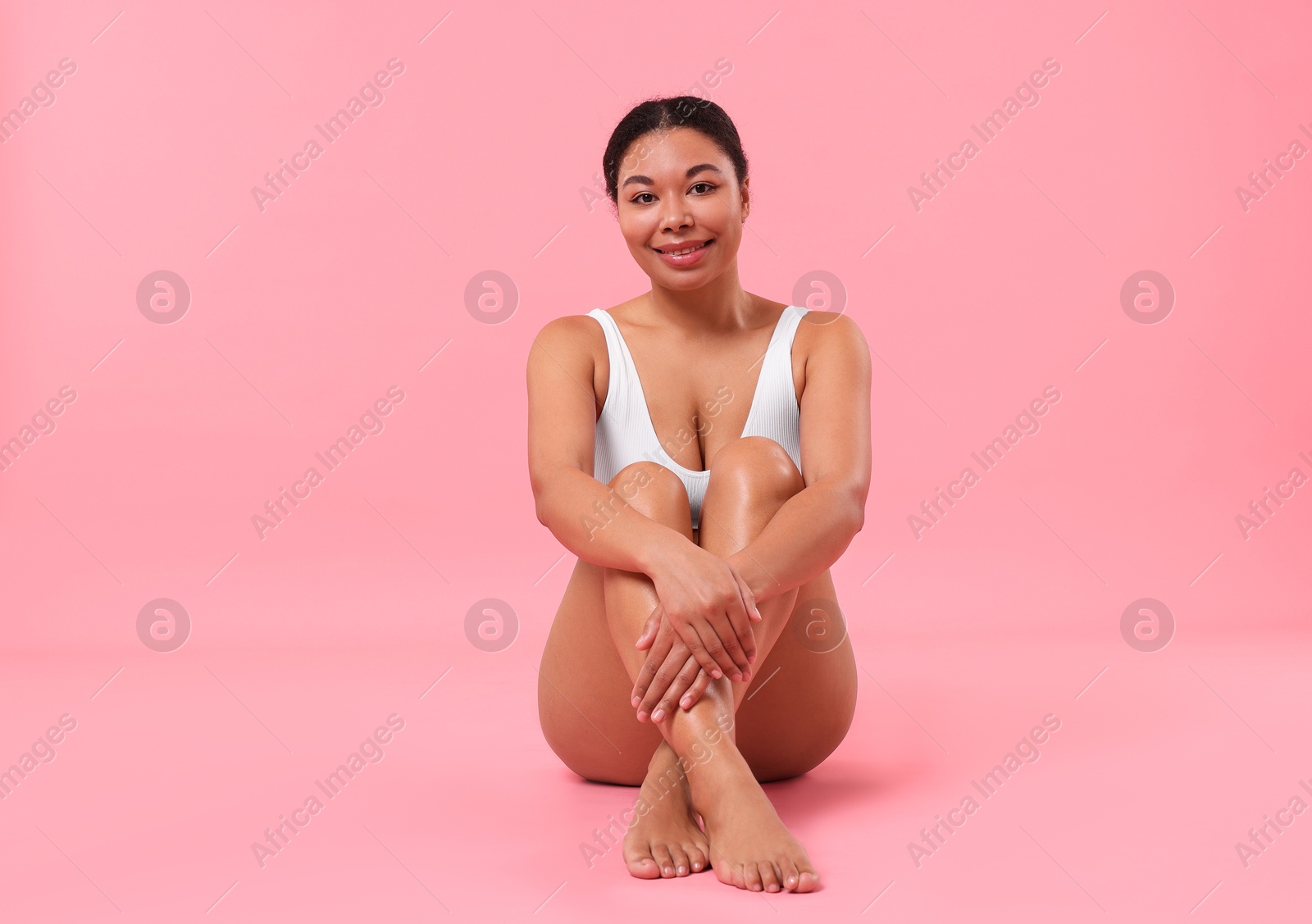 Woman in white underwear with smooth skin after epilation procedure on pink background Photo of Woman in white underwear with smooth skin after epilation procedure on pink background