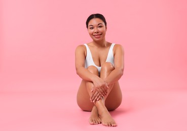 Photo of Woman in white underwear with smooth skin after epilation procedure on pink background