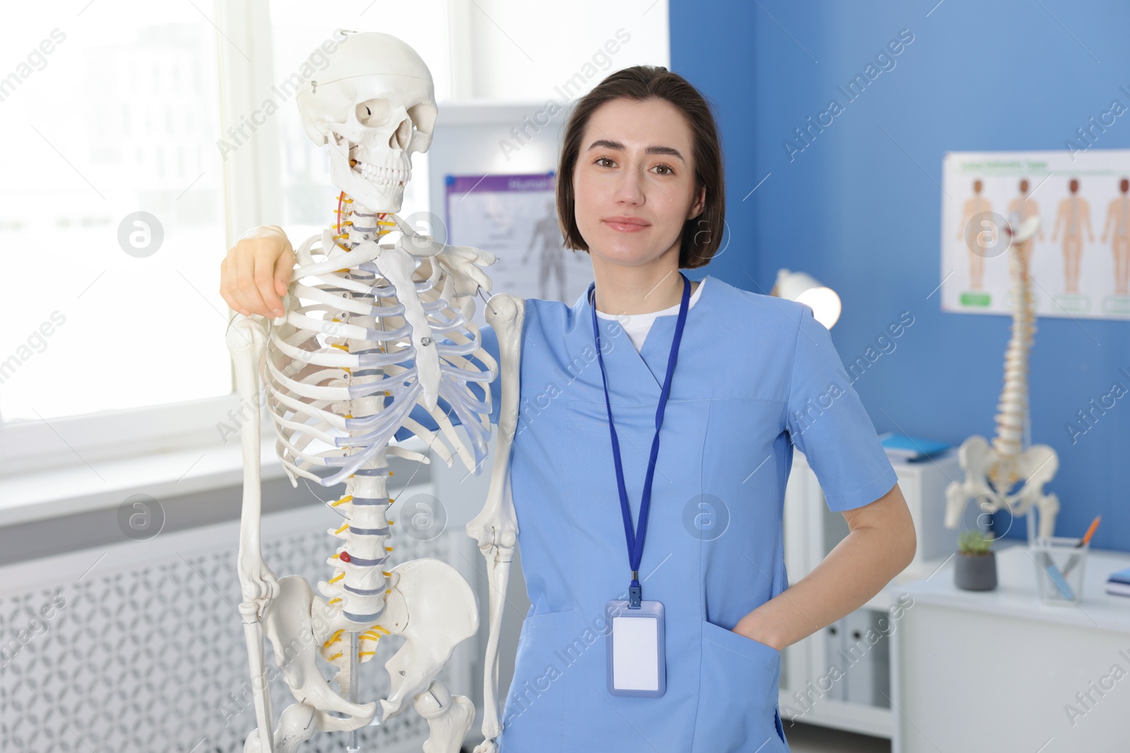 Doctor with human skeleton model in clinic Photo of Doctor with human skeleton model in clinic