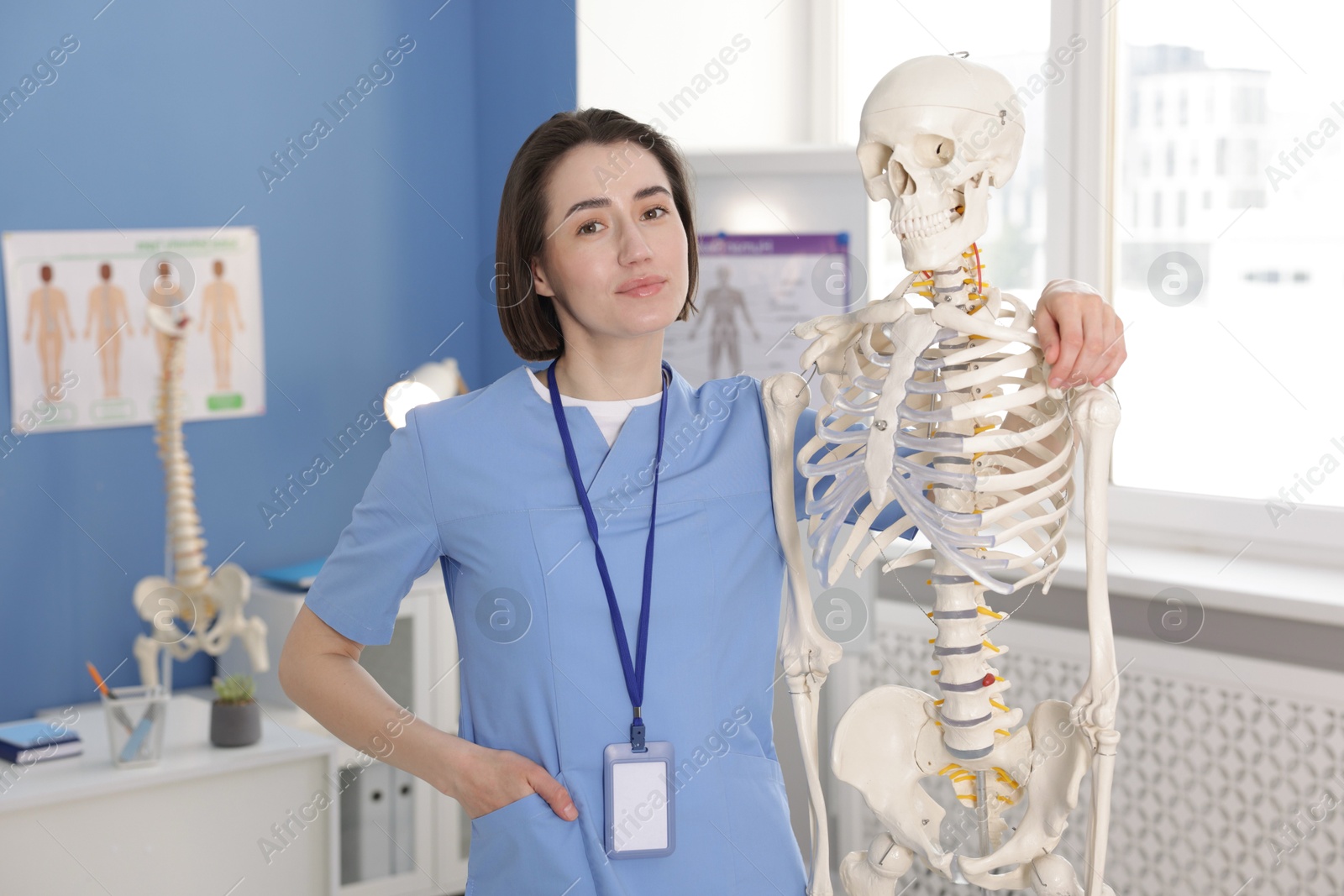 Doctor with human skeleton model in clinic Photo of Doctor with human skeleton model in clinic