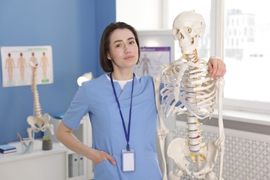 Photo of Doctor with human skeleton model in clinic