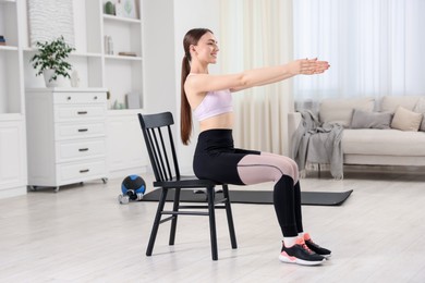 Photo of Beautiful woman stretching on chair at home
