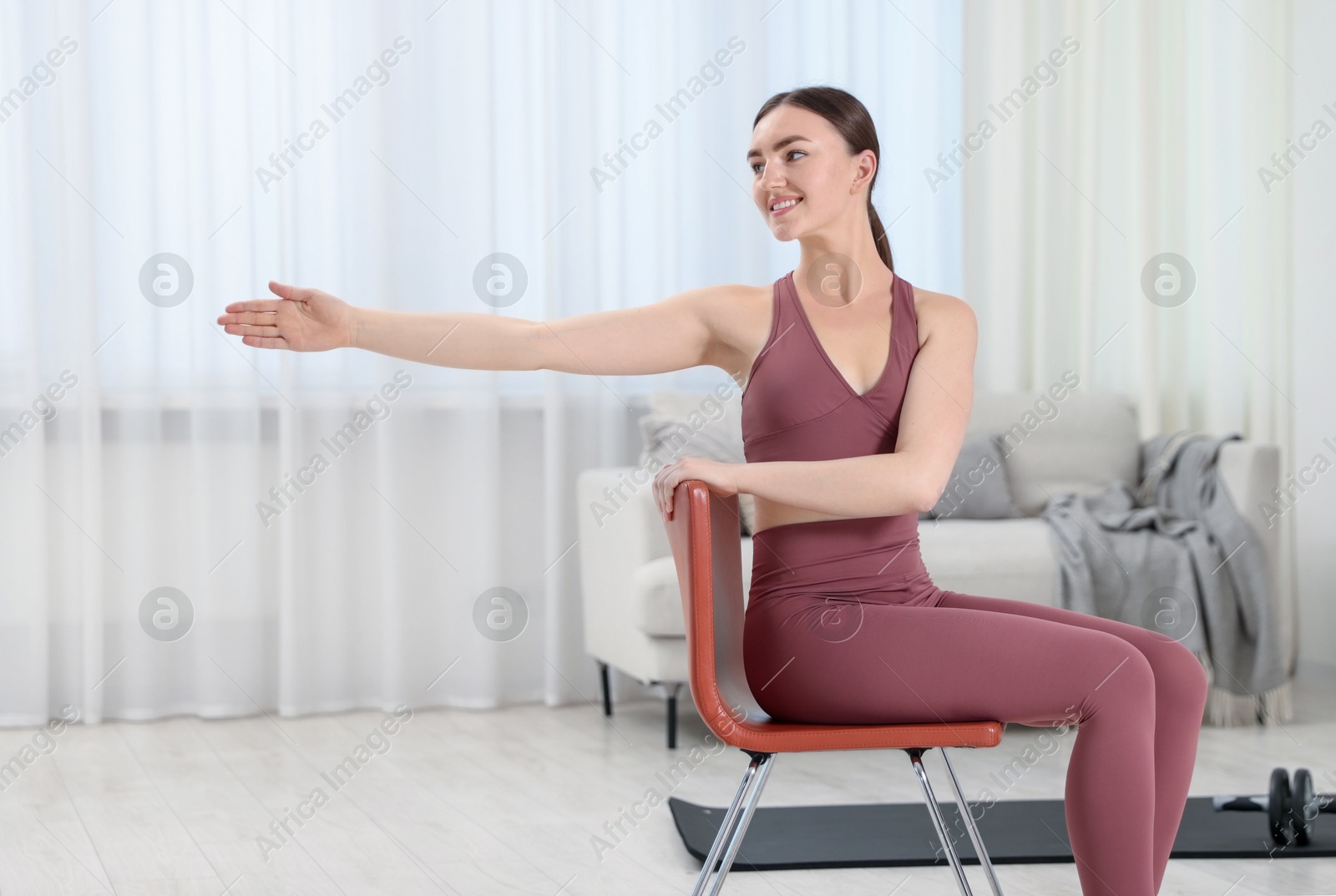 Beautiful woman stretching on chair at home Photo of Beautiful woman stretching on chair at home