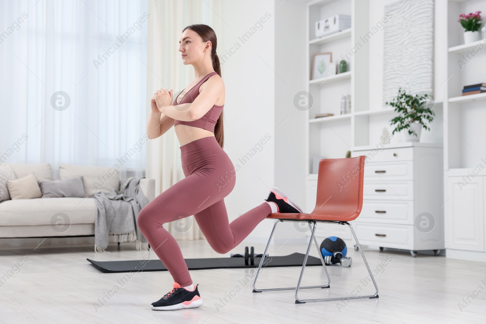 Beautiful woman exercising with chair at home Photo of Beautiful woman exercising with chair at home