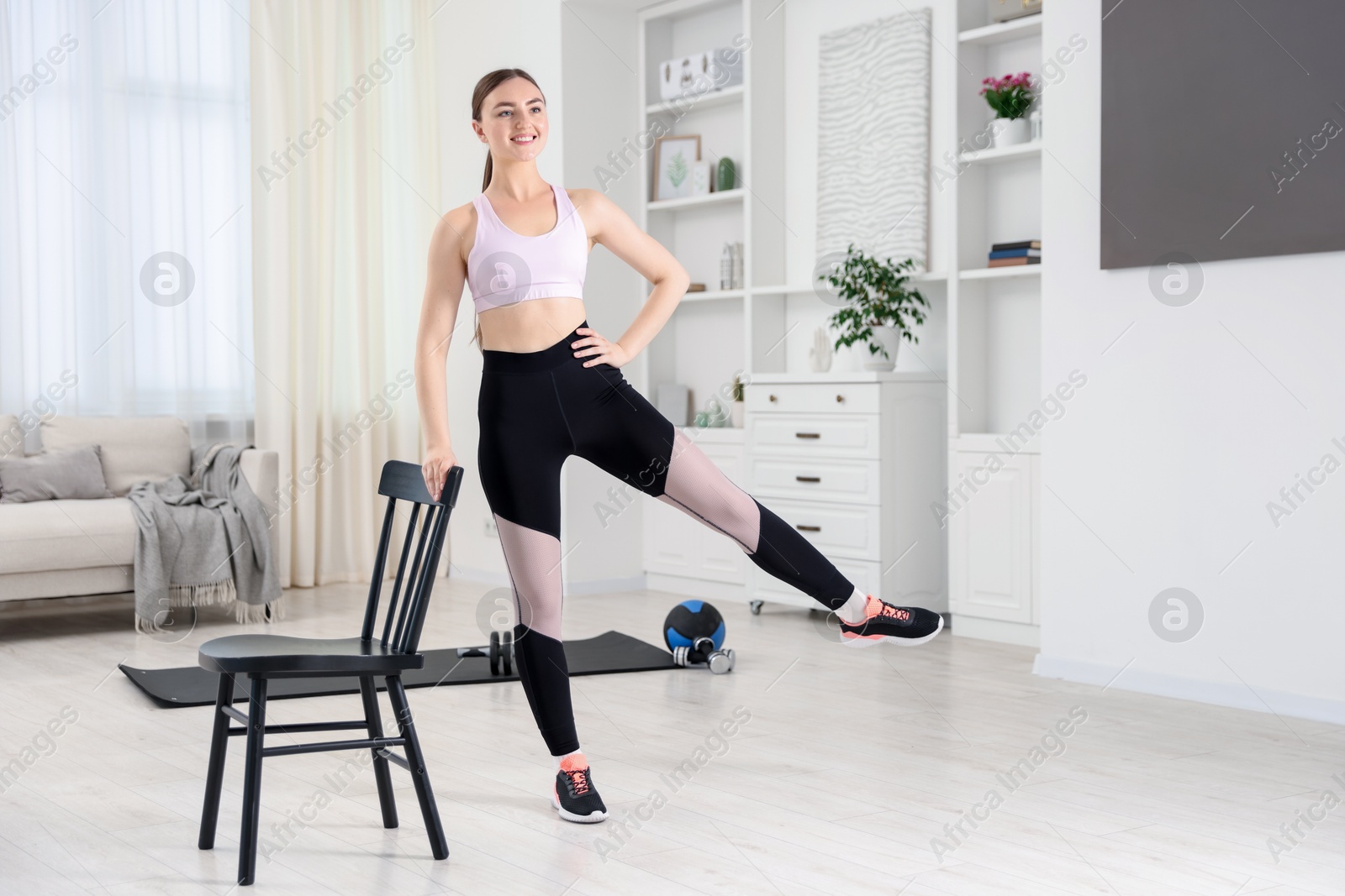 Beautiful woman exercising with chair at home Photo of Beautiful woman exercising with chair at home