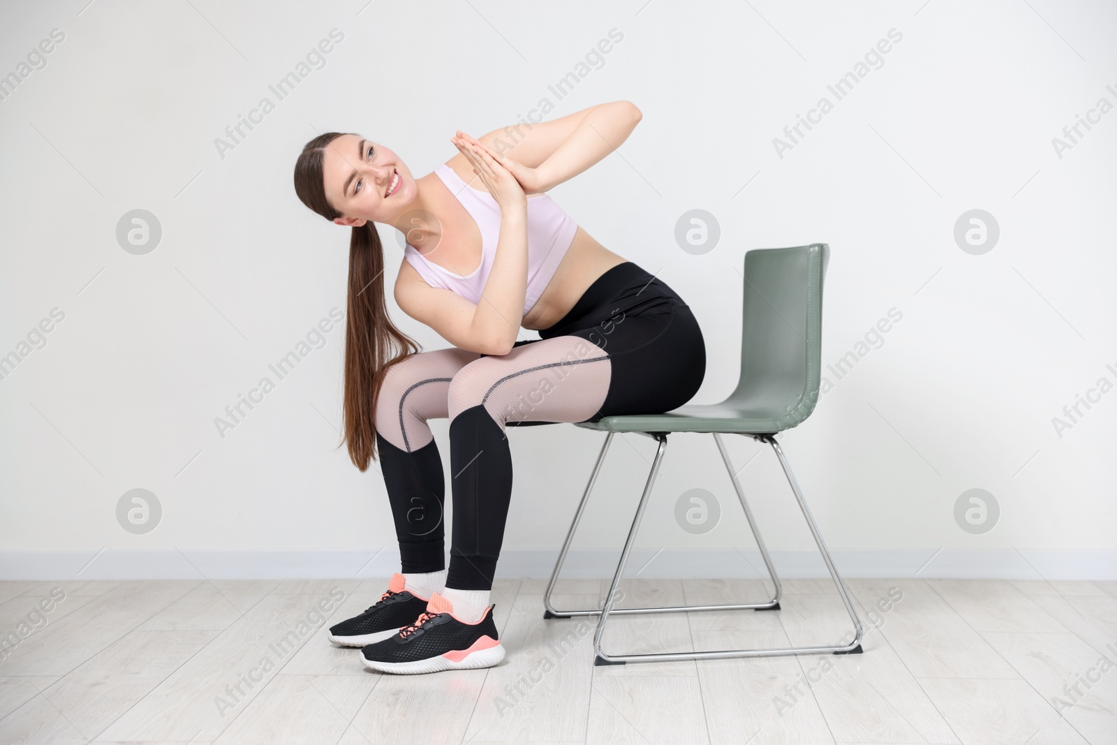 Beautiful woman stretching on chair at home Photo of Beautiful woman stretching on chair at home