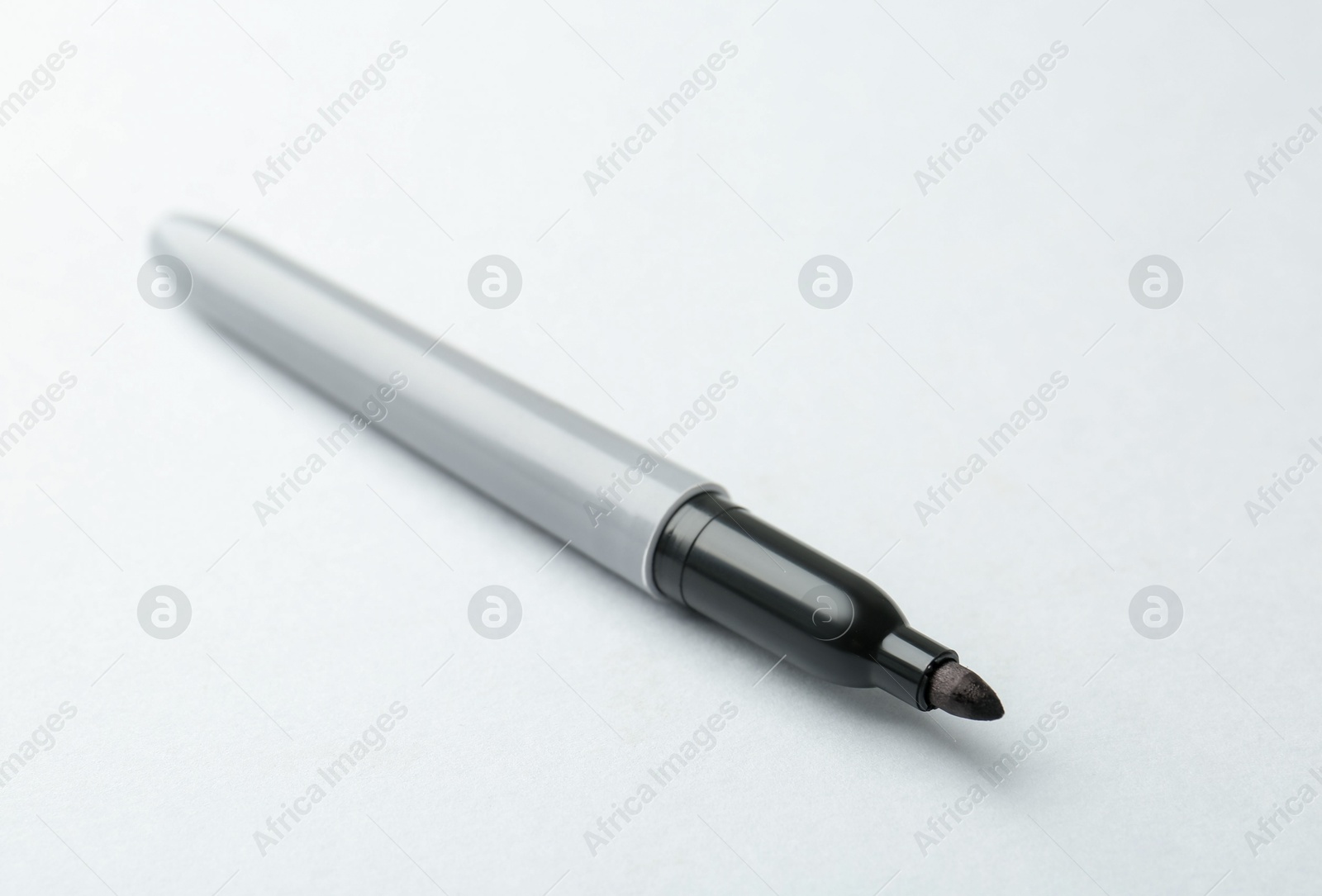 One black marker on light background, closeup. Space for text Photo of One black marker on light background, closeup. Space for text