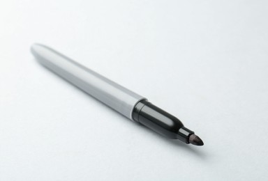 Photo of One black marker on light background, closeup. Space for text