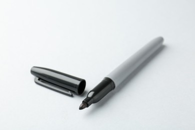 Photo of One black marker on light background, closeup. Space for text
