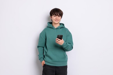 Photo of Teenage boy with smartphone on white background