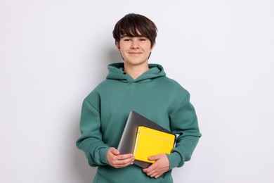 Photo of Teenage boy with laptop and notebook on white background