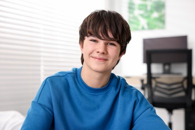 Photo of Portrait of happy teenage boy at home