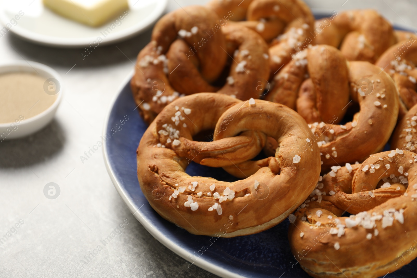 Tasty pretzels and ingredients on grey table, closeup Photo of Tasty pretzels and ingredients on grey table, closeup
