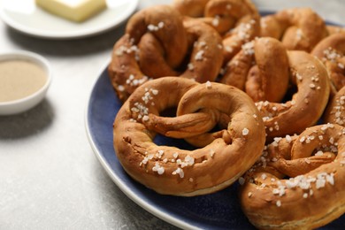 Photo of Tasty pretzels and ingredients on grey table, closeup