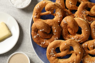 Photo of Tasty pretzels and ingredients on grey table, flat lay