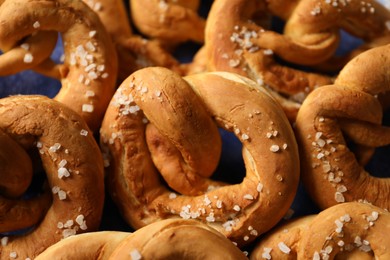 Photo of Tasty pretzels with salt on plate, closeup