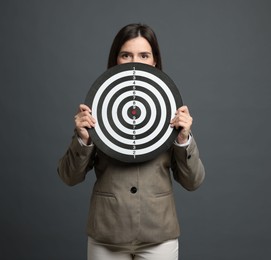 Photo of Targeting. Businesswoman with dart board on grey background