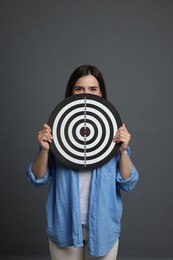 Photo of Targeting. Woman with dart board on grey background