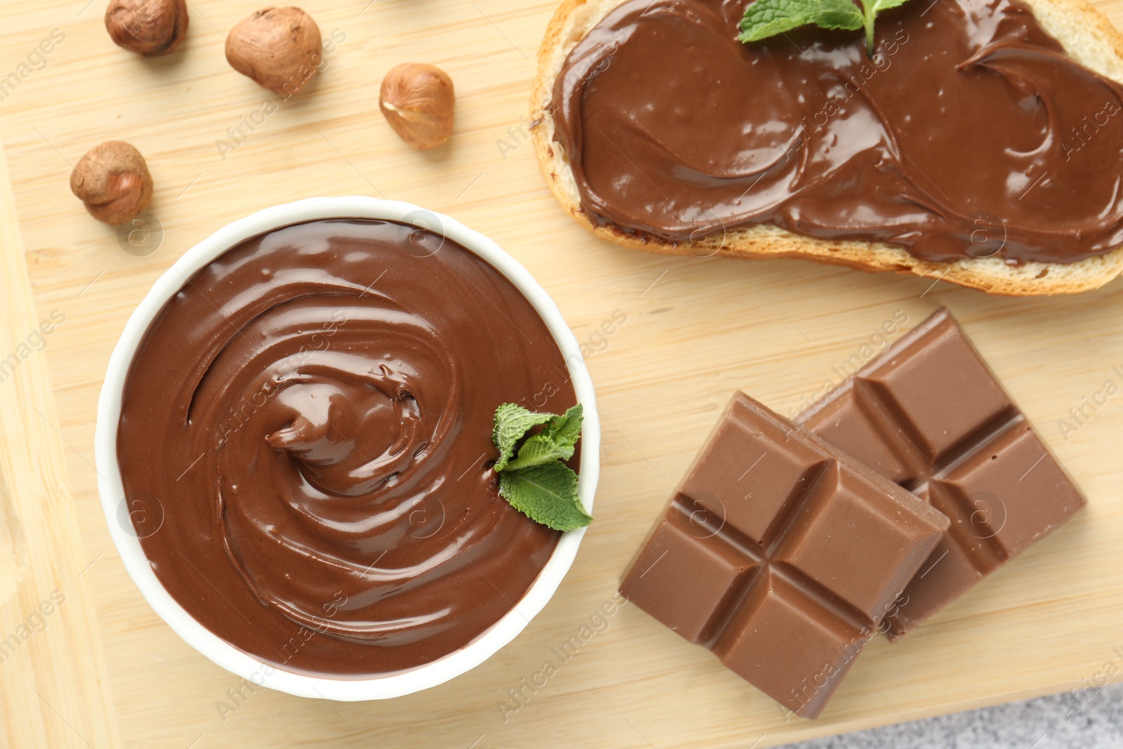 Tasty chocolate spread, toast, hazelnuts and mint on table, top view Photo of Tasty chocolate spread, toast, hazelnuts and mint on table, top view